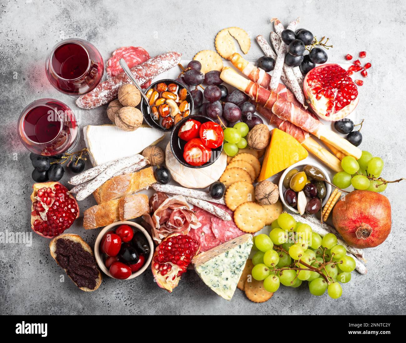 Festliche Gourmet-Mischung aus Snacks und Vorspeisen, Käse, Fleisch, Oliven, Brot, Obst, Kanapees, Wein in Gläsern. Italienisches Antipasti-Set oder spanische Tapas Stockfoto