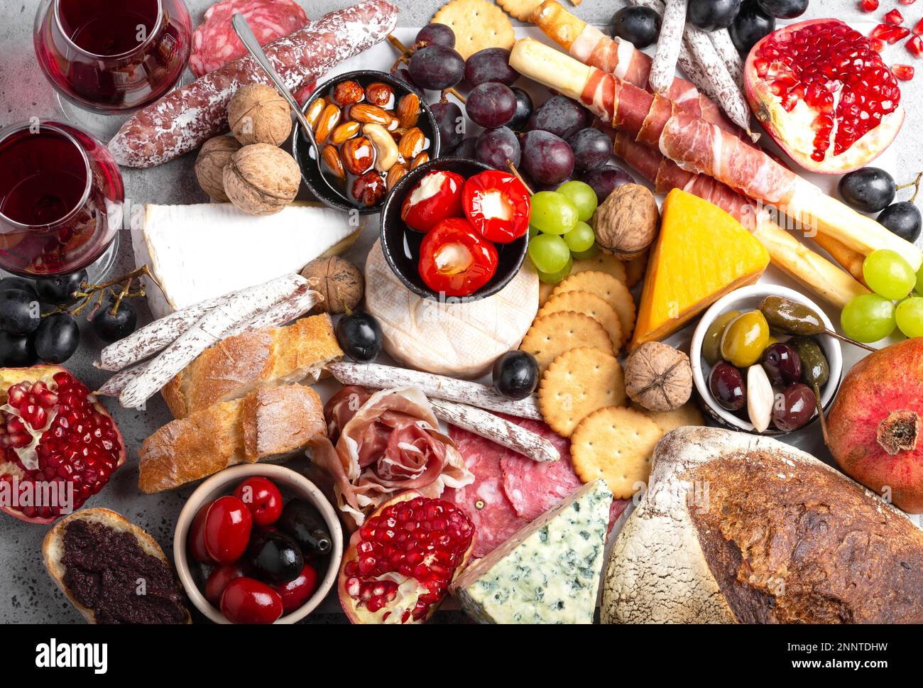 Festliche Gourmet-Mischung aus Snacks und Vorspeisen, Käse, Fleisch, Oliven, Brot, Obst, Kanapees, Wein in Gläsern. Italienisches Antipasti-Set oder spanische Tapas Stockfoto