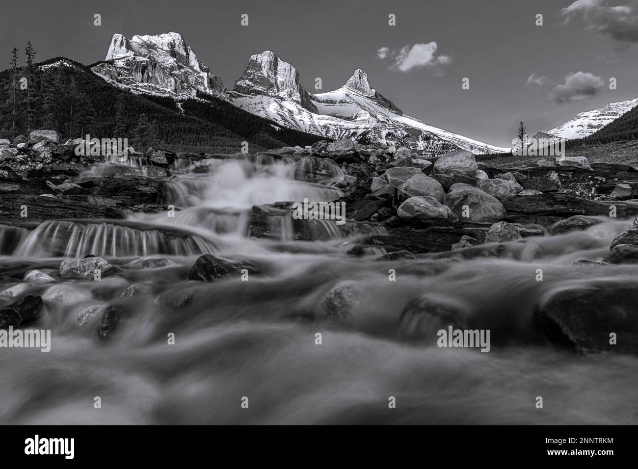 Wasserfall unter Three Sisters Mountain in Schwarz und Weiß, Three Sisters Creek, Canmore, Alberta, Kanada Stockfoto