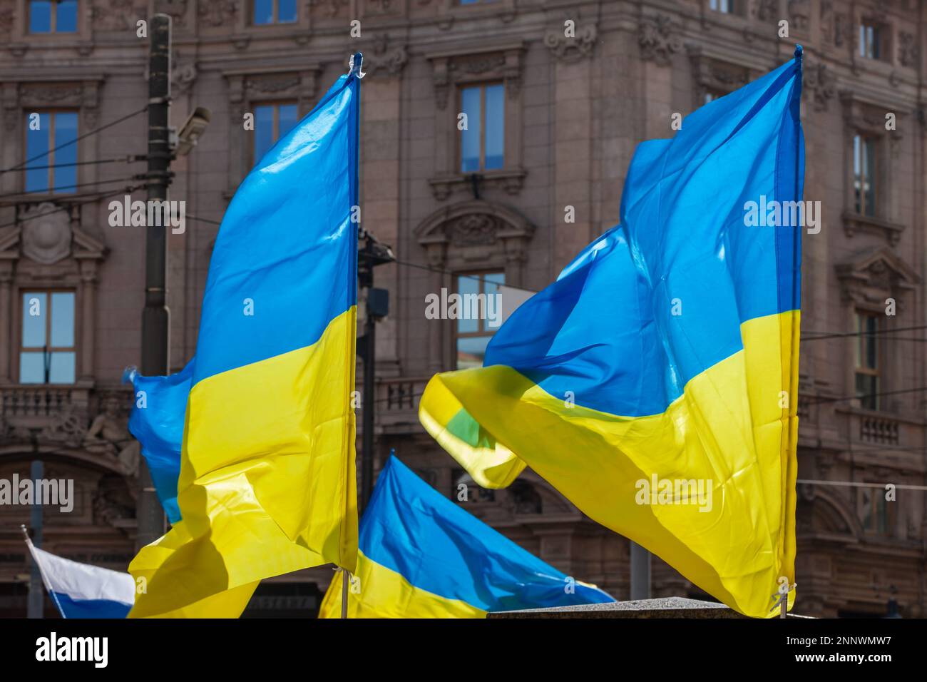 Flagge mit gelb-blau gestreiften Farben der Ukraine, die im Wind mit blauem Himmel und Sonne winkt. Stockfoto