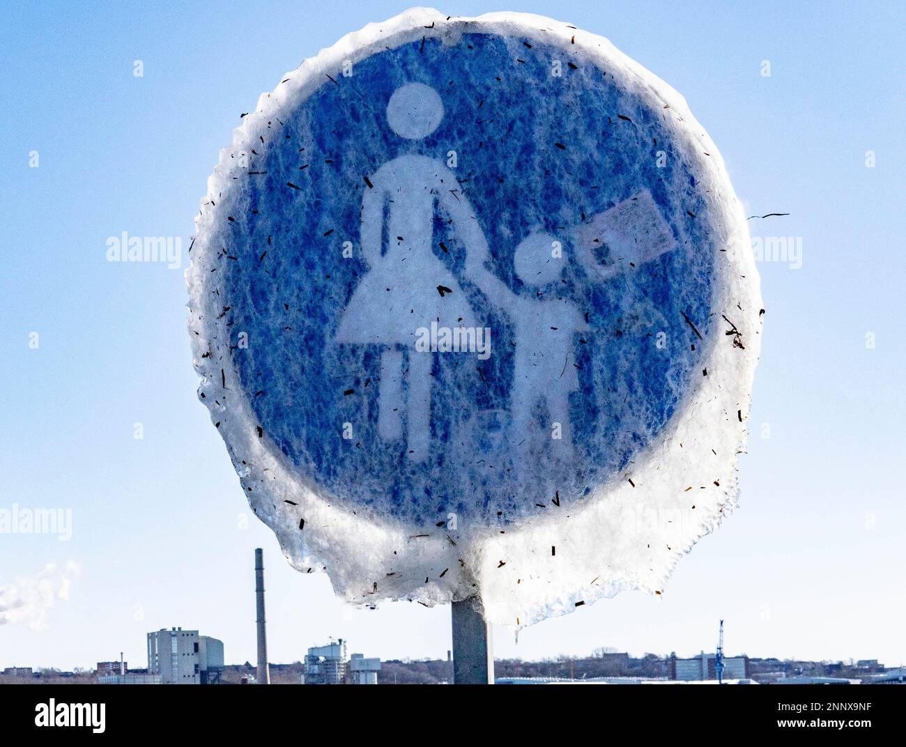 A road sign indicating a pedestrian path and completely covered with ice stands on the shore of the Kiel Fjord in Strande, Germany. Friday, Feb. 12, 2021. Parts of Germany are hit by low temperatures under zero degree celsius. (Axel Heimken/dpa via AP) Stockfoto
