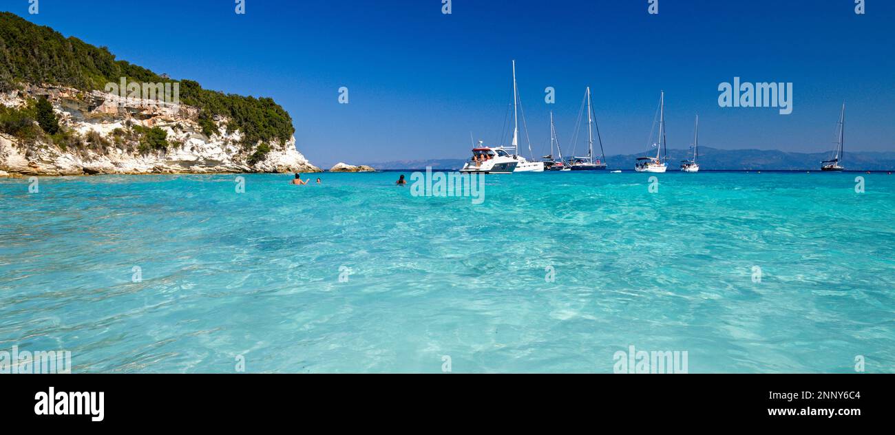 Wellen im Meer und Segelboote in Lakka Bay, Paxos, Ionische Inseln, Griechenland Stockfoto