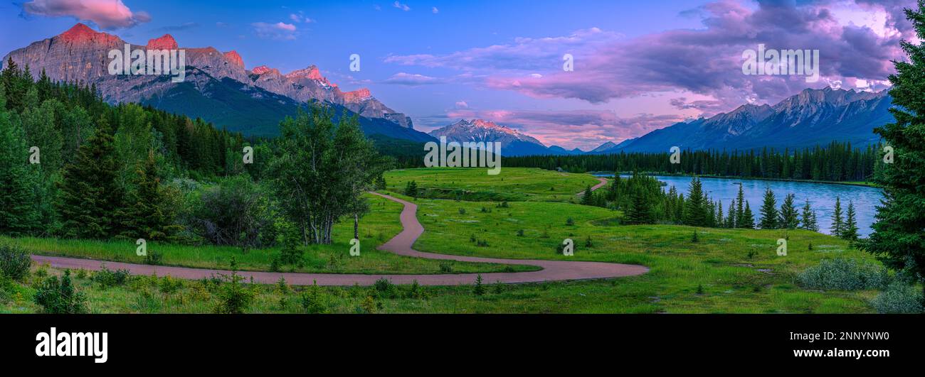 Wanderweg führt durch eine Wiese am Flussufer, Bow River, Mount Rundle, Cascade Mountain, Canmore, Alberta, Kanada Stockfoto