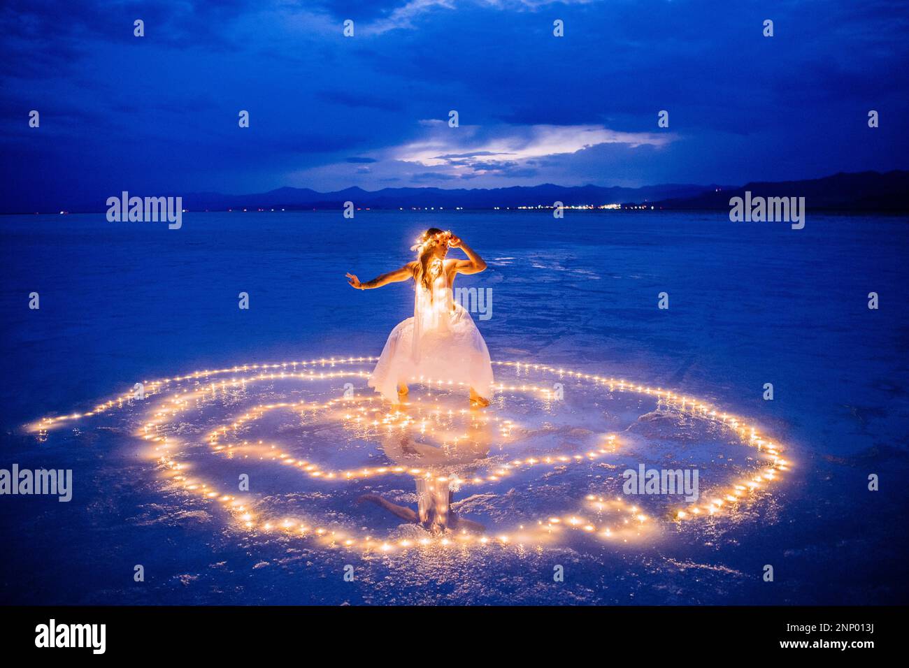 Eine Tänzerin, umgeben von einem Lichtkreis auf dem Wasser Stockfoto