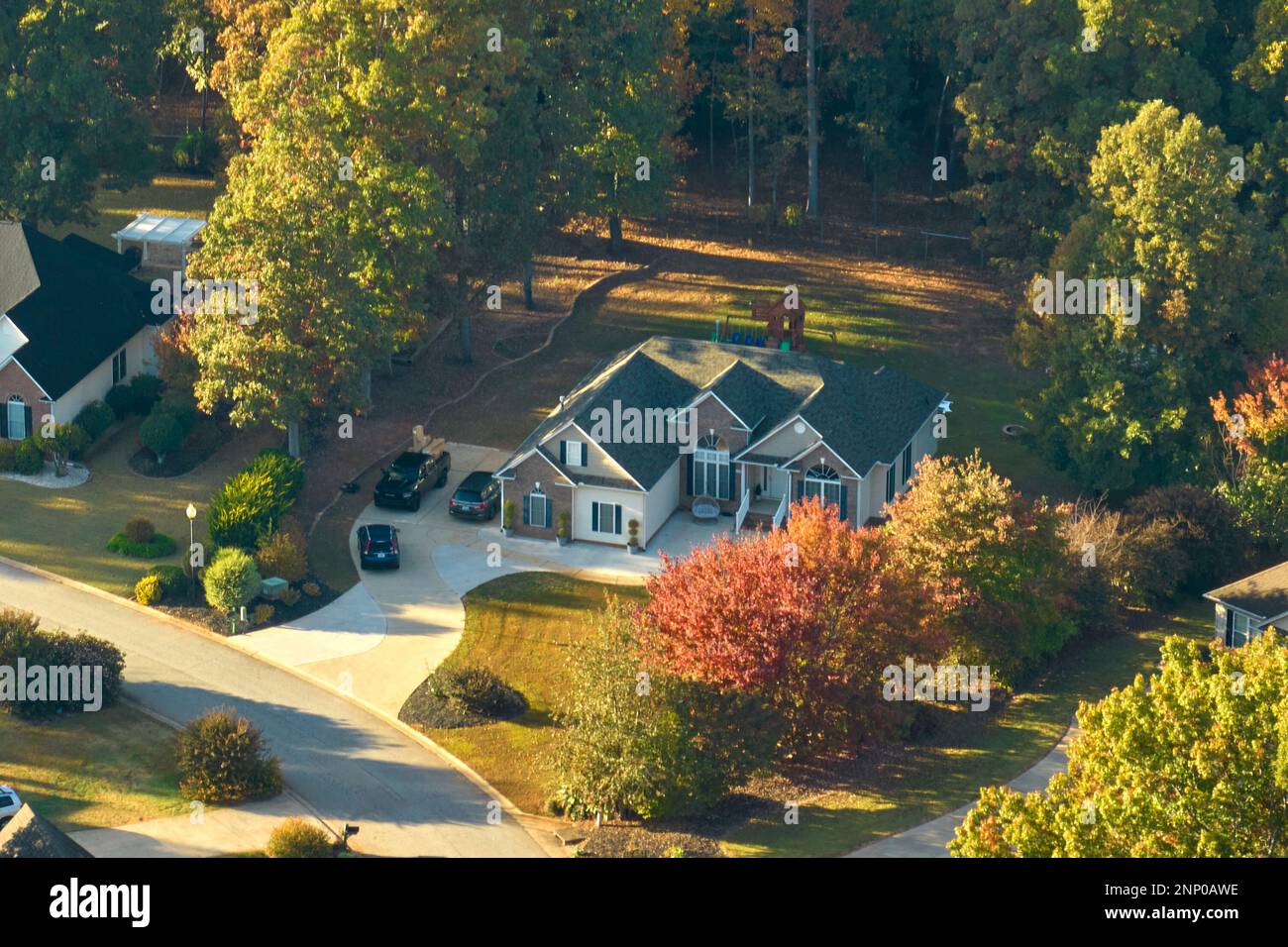 Blick aus der Vogelperspektive auf das neue Familienhaus zwischen gelben Bäumen im Vorort von South Carolina in der Herbstsaison. Immobilienentwicklung in amerikanischen Vorstädten. Stockfoto