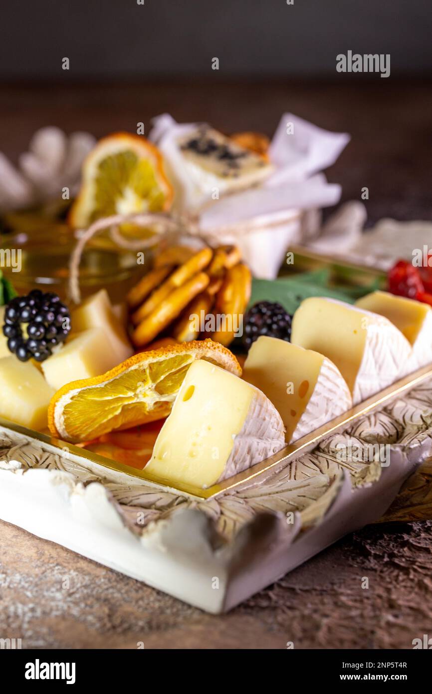Gemischter Käse auf einem Tablett mit Nüssen und Honig. Stockfoto