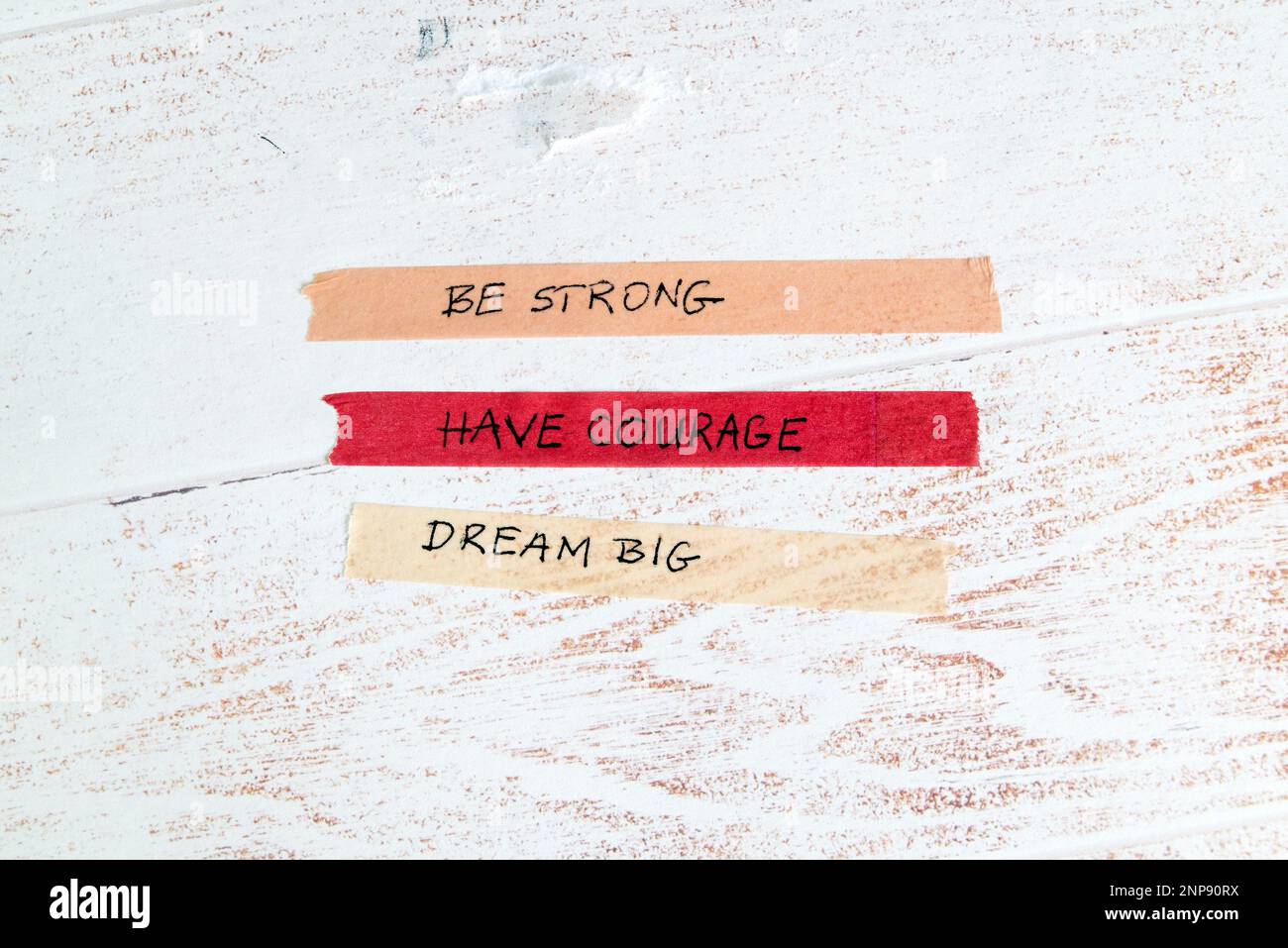 Motivationsbotschaft auf buntem Washi-Band auf weißem Holzhintergrund Stockfoto