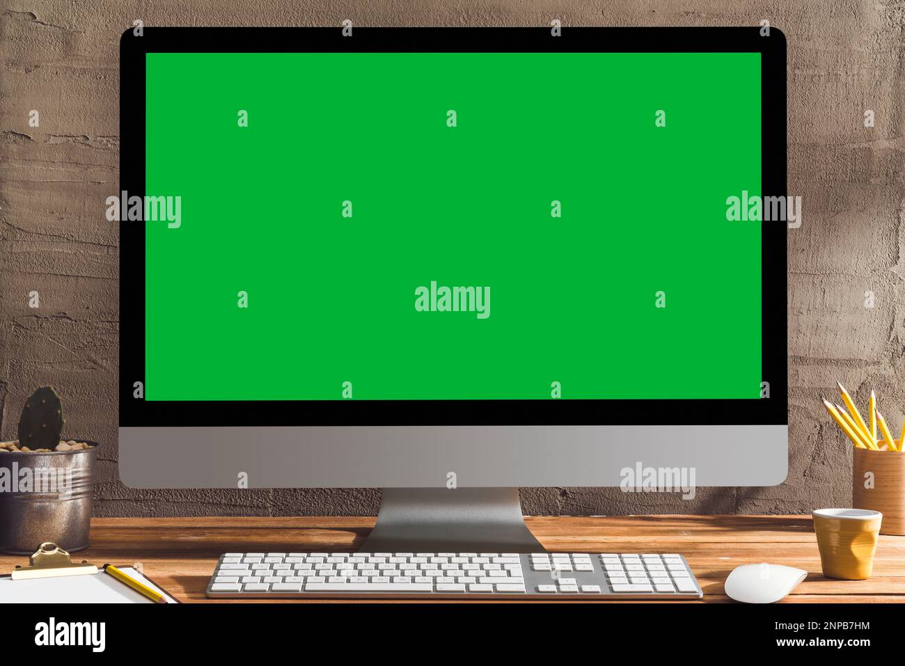 Chroma Key Green Screen Computer, Desktop pc auf Tisch. Tischaufnahme des Innenraums mit Fensterlichteffekt. Stockfoto