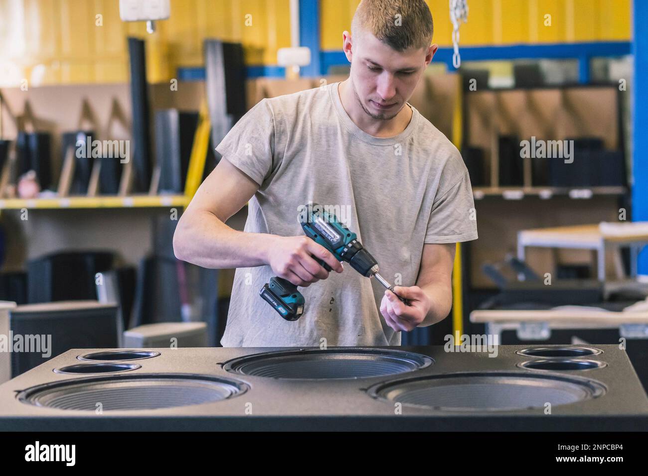 Der Arbeiter baut einen riesigen Lautsprecher in einer Fabrik zusammen Stockfoto