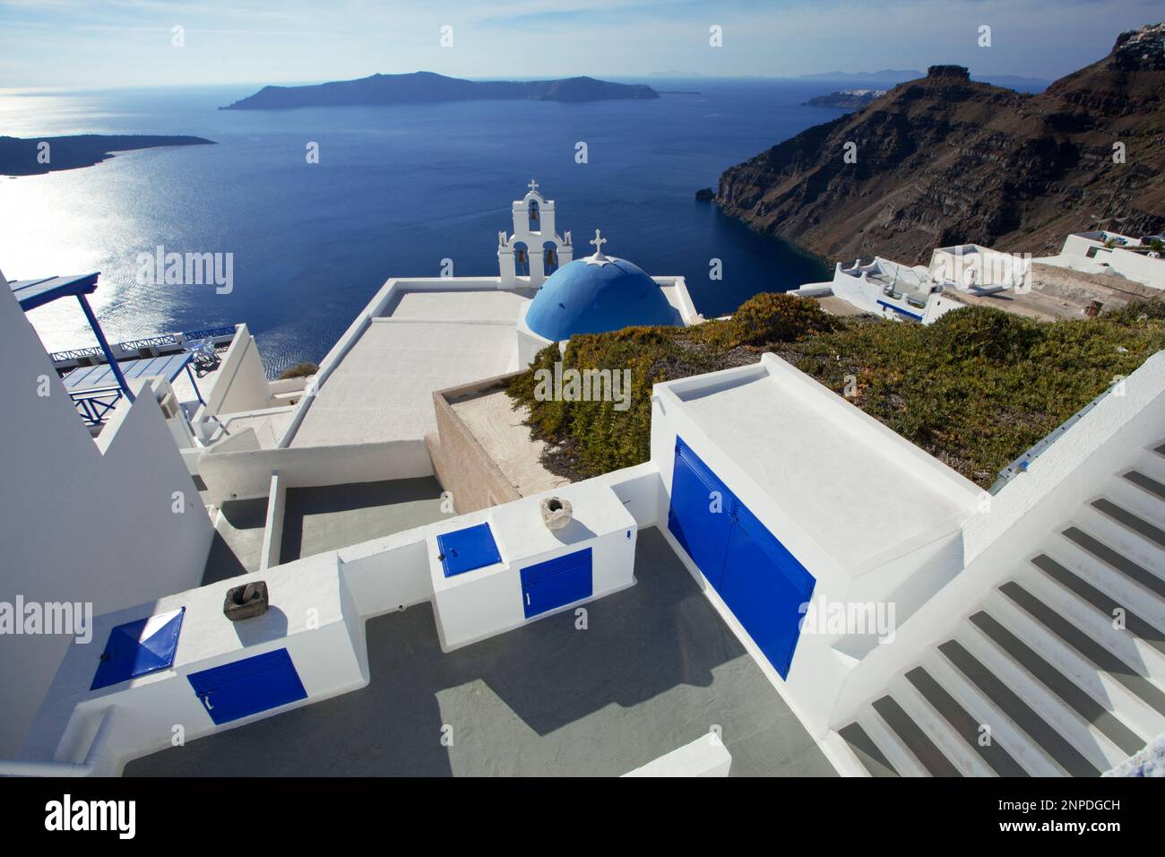 Ein Blick auf eine berühmte blaue Kuppelkirche mit der Caldera und Meer hinaus. Stockfoto