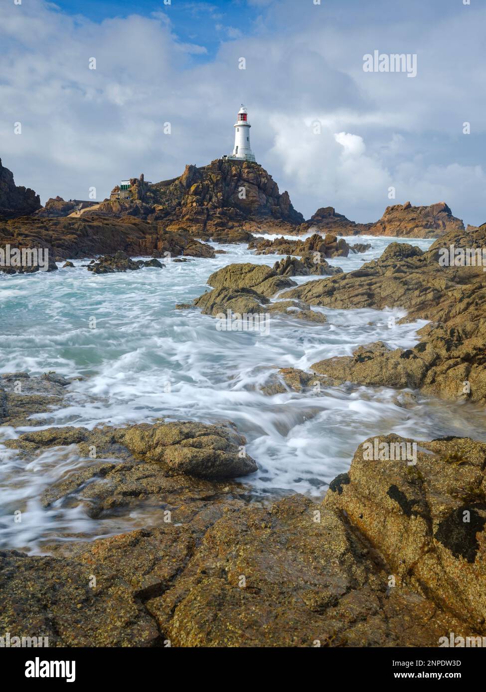 Leuchtturm von Corbiere mit Ebbe unter blauem Sommerhimmel. Stockfoto