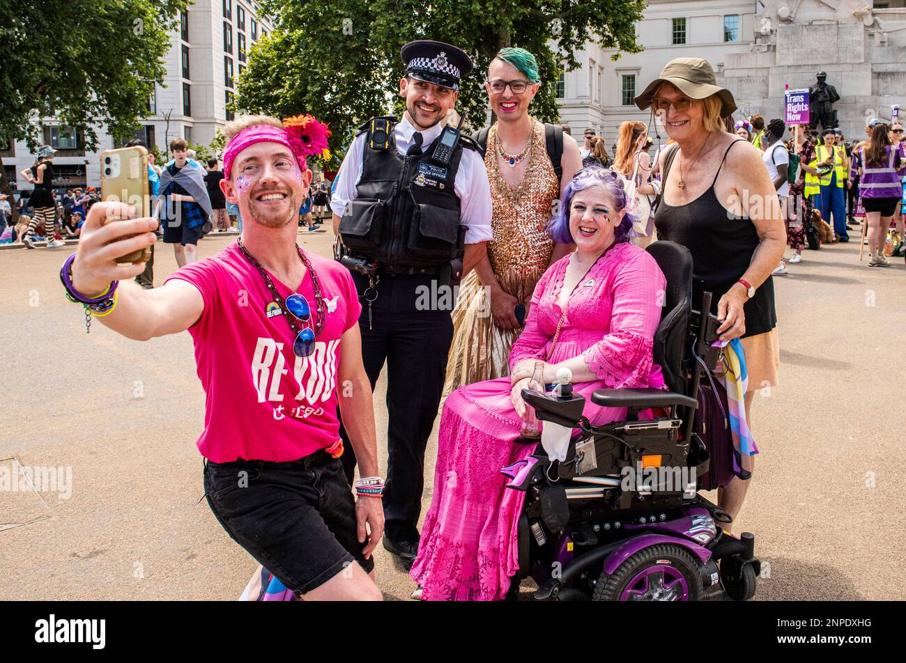 Eine bunte Gruppe von Mitgliedern der LGBTQ+ Community posiert für ein Selfie mit einem Offizier der Metropolitan Police, während sie gegen das Fehlen protestieren Stockfoto