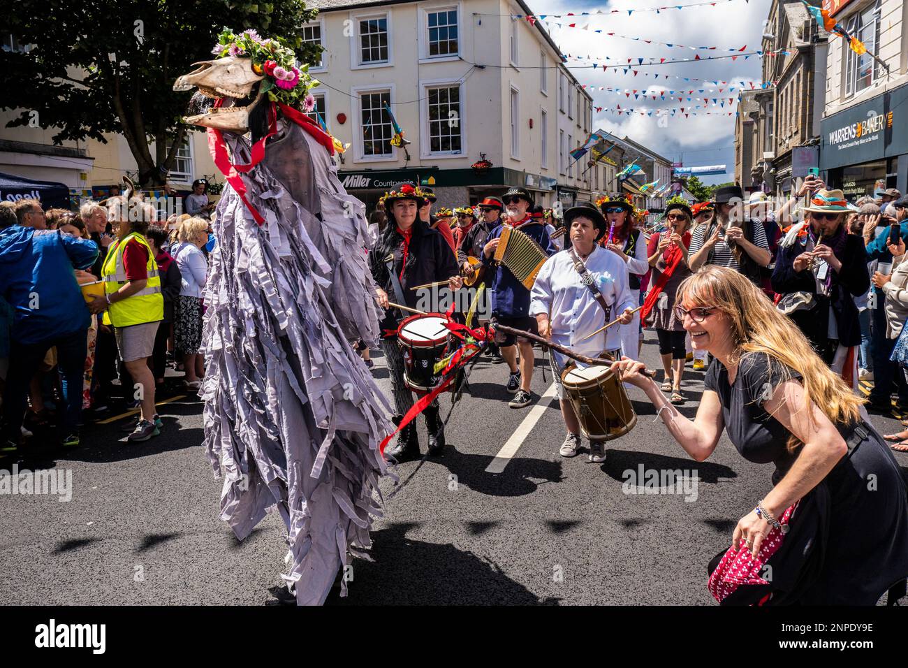 Penglaz The Penzance Obby Oss und der Teazer the Bucca mit Musikern der Raffidy Dumitz Band, die am Mazey Day während des Golowan Festivals in Cornwall, England, die Bürgerprozession leiteten. Stockfoto