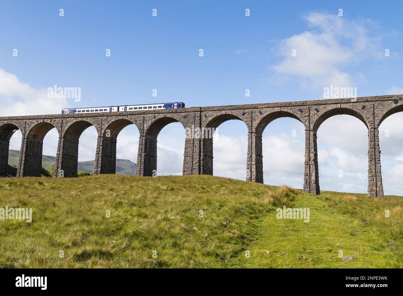 Ein Zug fährt über das dramatische Ribblehead Viaduct auf der Settle to Carlisle Railway über das Ribble Valley. Stockfoto