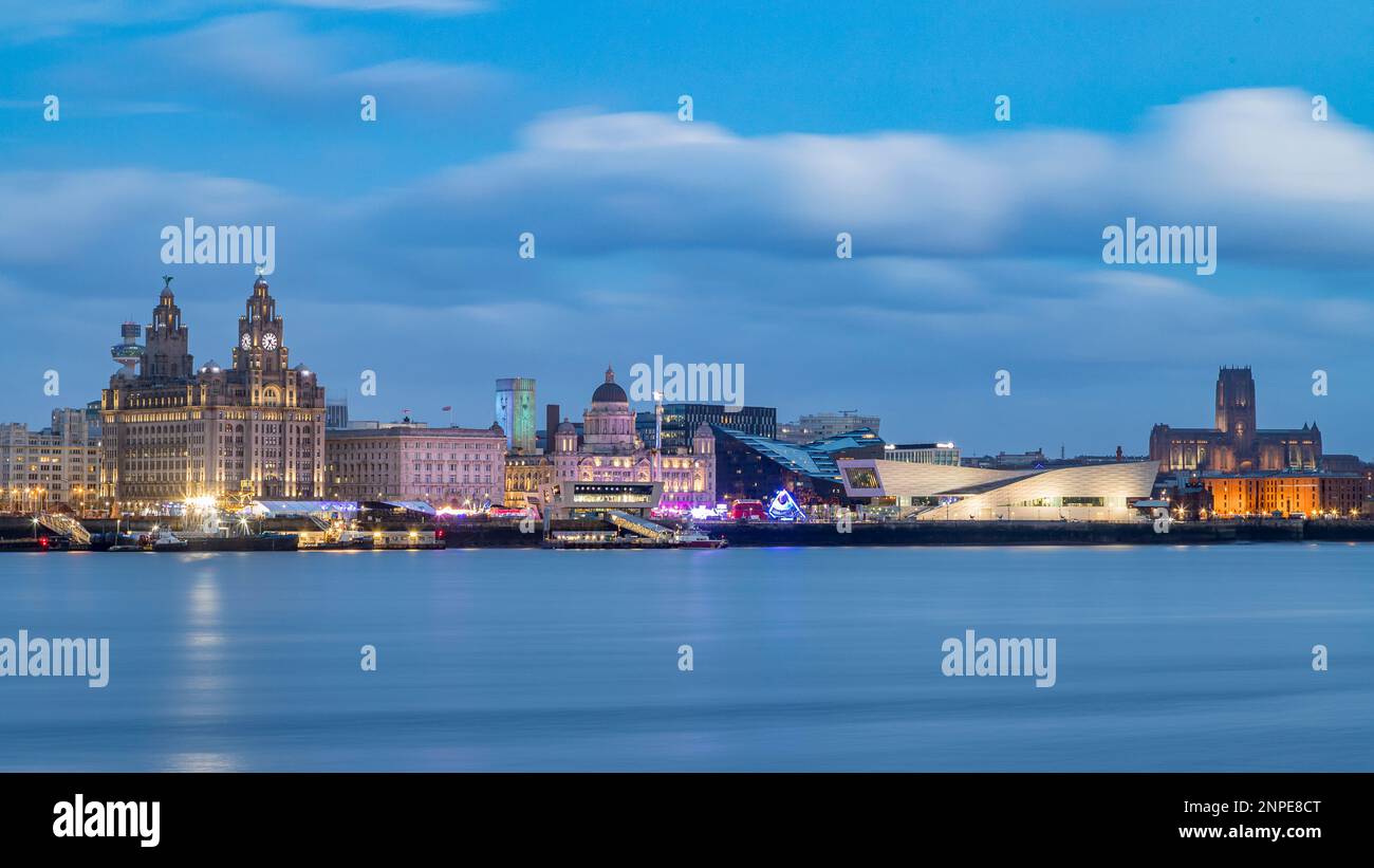 Das Hafengebiet von Liverpool beginnt während der Blue Hour am Neujahrstag 2022 zu leuchten. Stockfoto