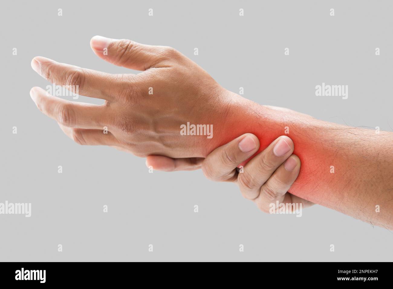 Der Mann hat Taubheit im Unterarm auf grauem Hintergrund. Gesundheits- und Körperpflegekonzept. Stockfoto