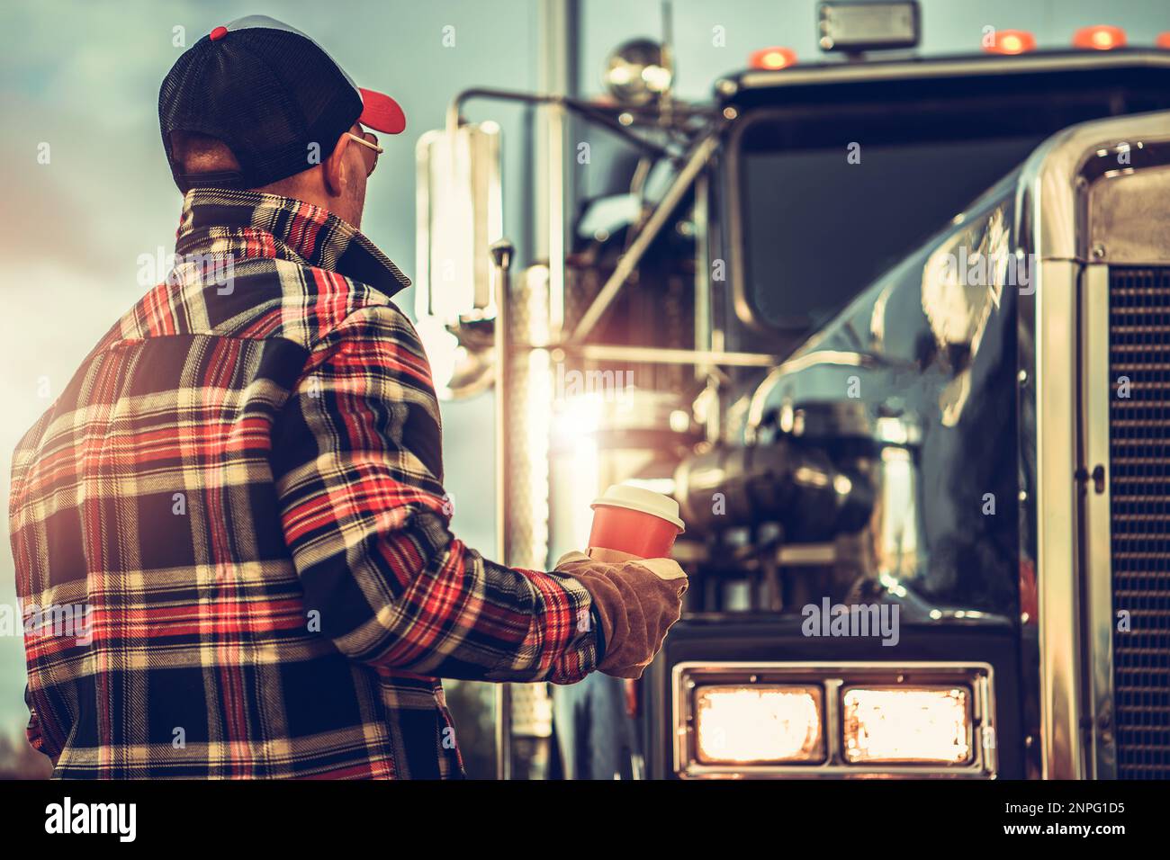 Us-Schwerlasttransporte. Sattelzugfahrer bereitet sich auf seine Arbeit vor und beendet seine Tasse Kaffee. Lkw-Stopp-Theme. Stockfoto