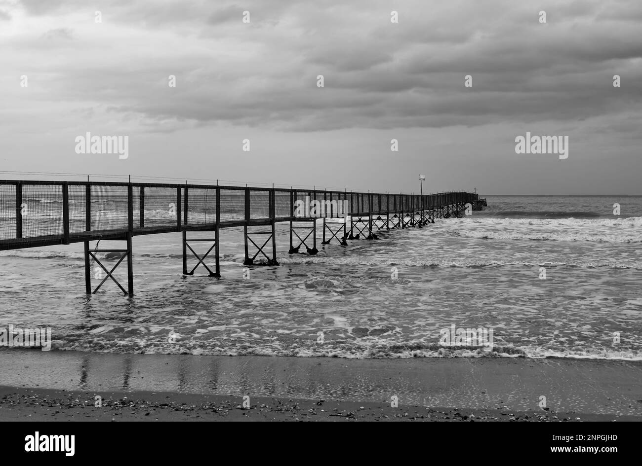 Minimale schwarz-weiße Landschaft mit langem Pier im Meer Stockfoto