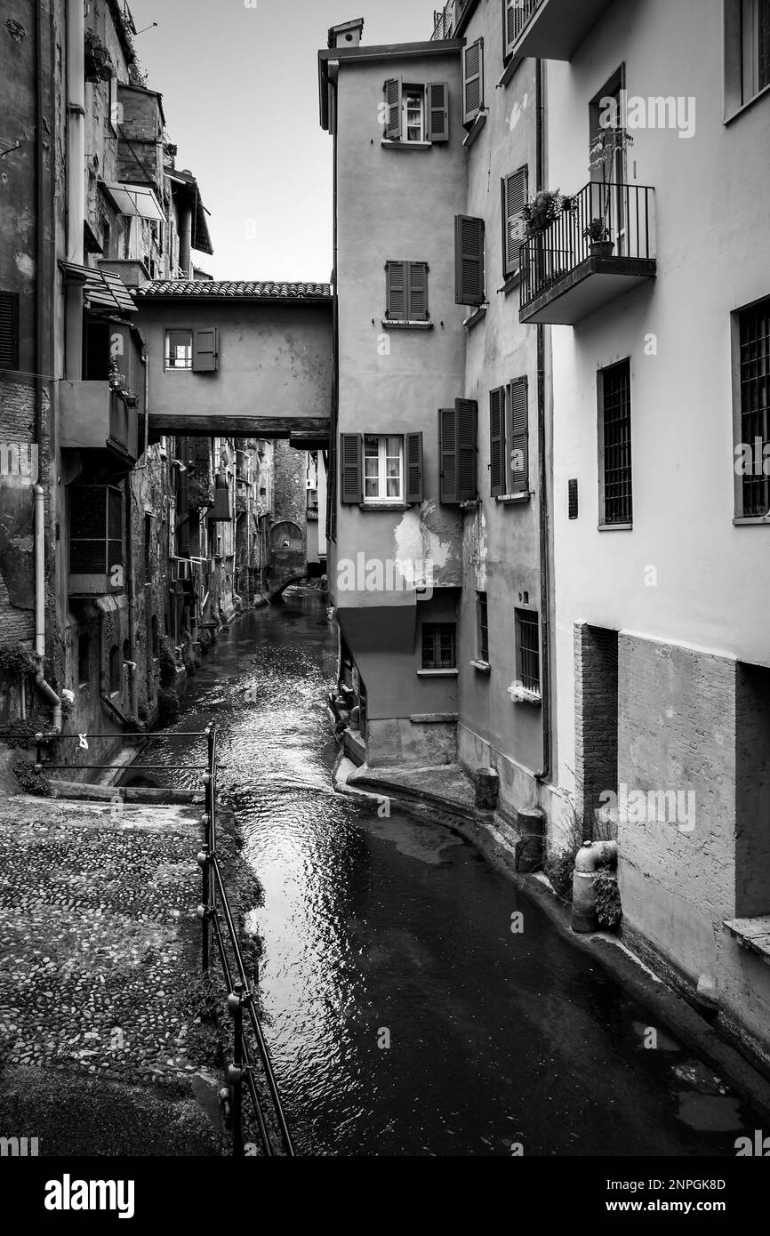 Versteckter Kanal in Bologna, Italien. Schwarzweiß-Fotografie in der Stadt Stockfoto