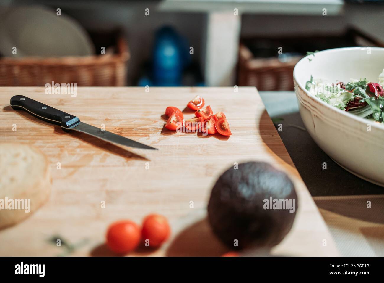 Scheiben einer Kirschtomate auf dem Küchenbrett. Salatzubereitung. Gesunde Ernährung Stockfoto