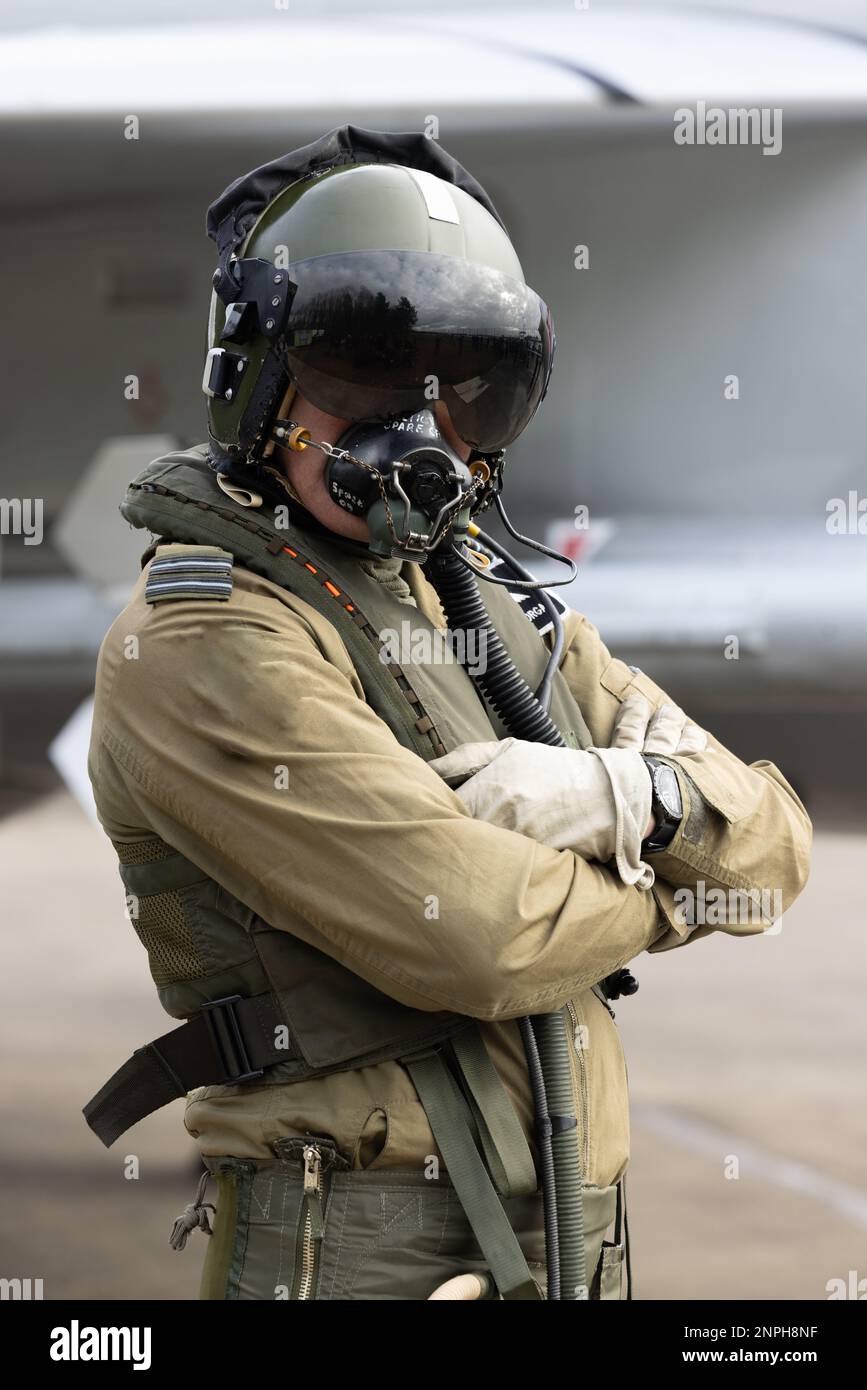 Militärischer Kampfpilot mit Helm, Visier und Sauerstoffmaske im Fluganzug mit Kampfjet im Hintergrund. Top-Stellung für Kampfpilot Stockfoto