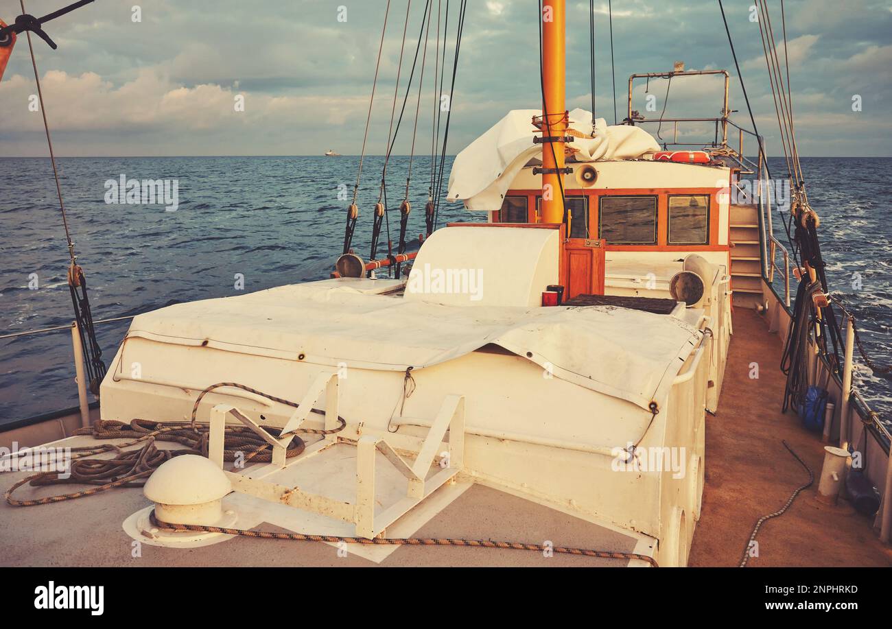 Alter Schoner segelt bei Sonnenuntergang, Farbtönung angewendet. Stockfoto
