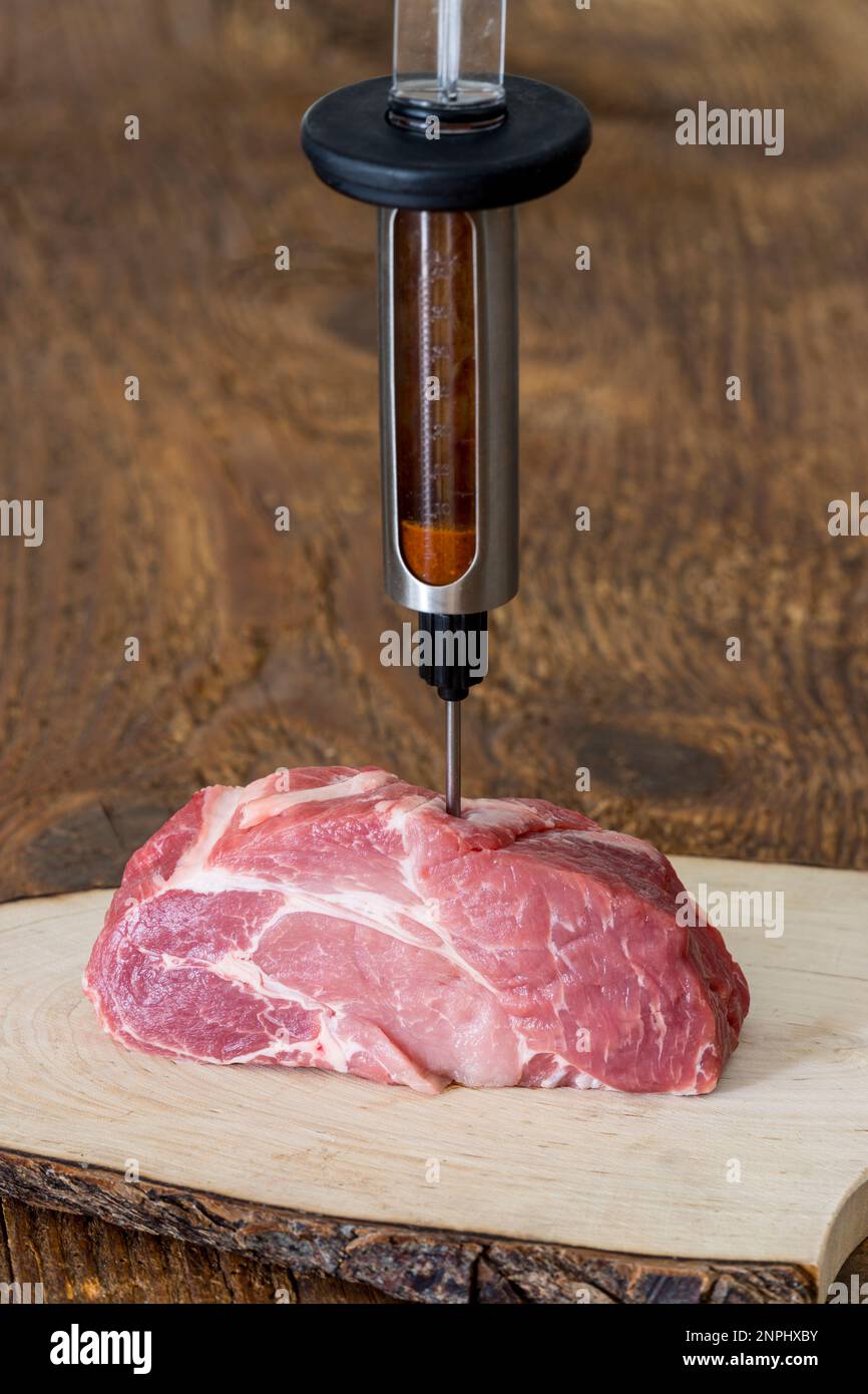 Marinade in Schweinefleisch injizieren Stockfoto