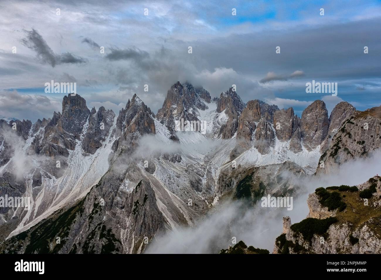 Die felsigen Gipfel des Berges Cadini di Misurina, teilweise von Wolken umhüllt und mit frischem Schnee bedeckt. Stockfoto