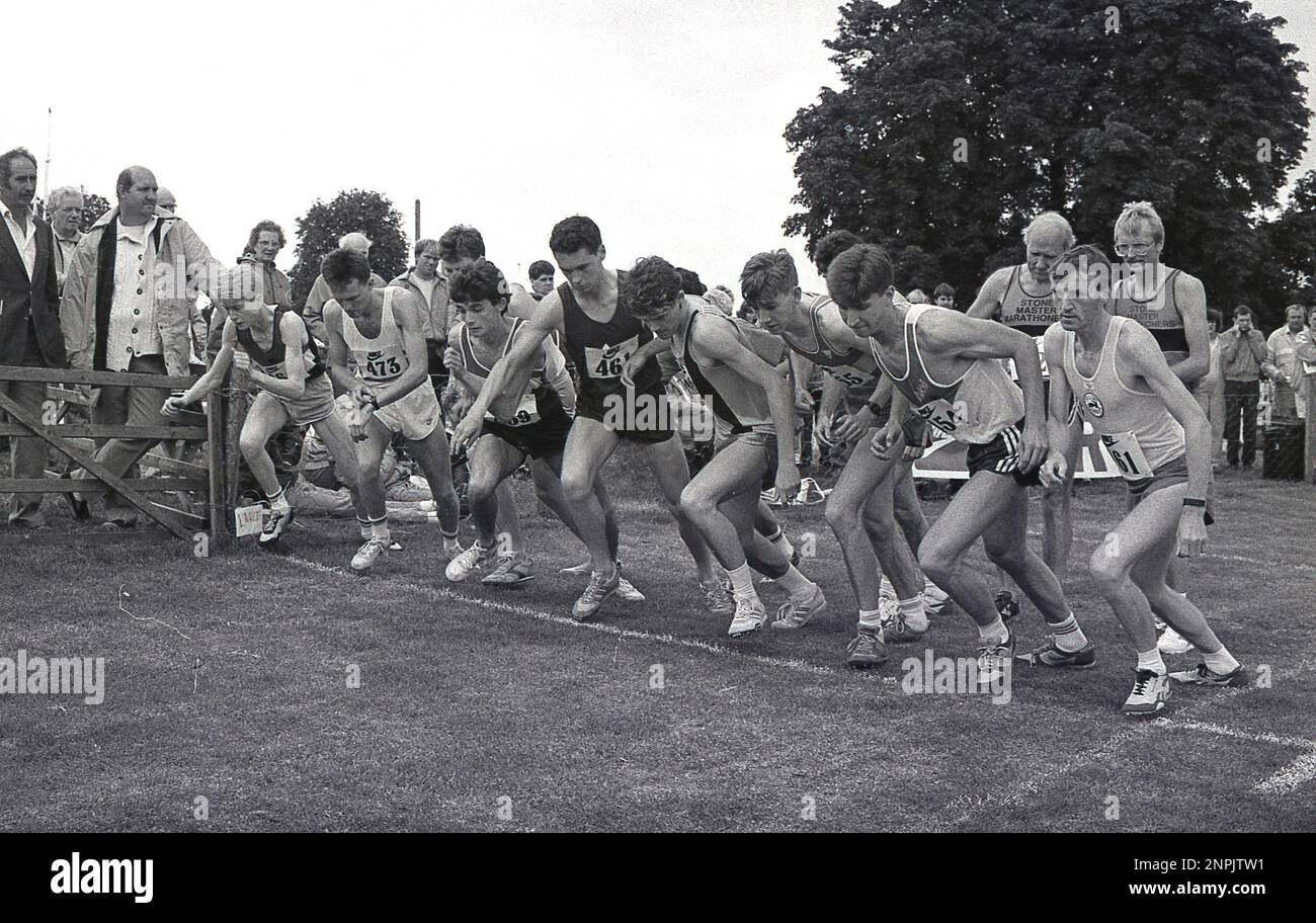 1988, historisch, draußen auf einem Feld, eine Gruppe männlicher Amateurläufer, die anstehen, um ein Park Running Rennen zu starten, England, Großbritannien. Stockfoto