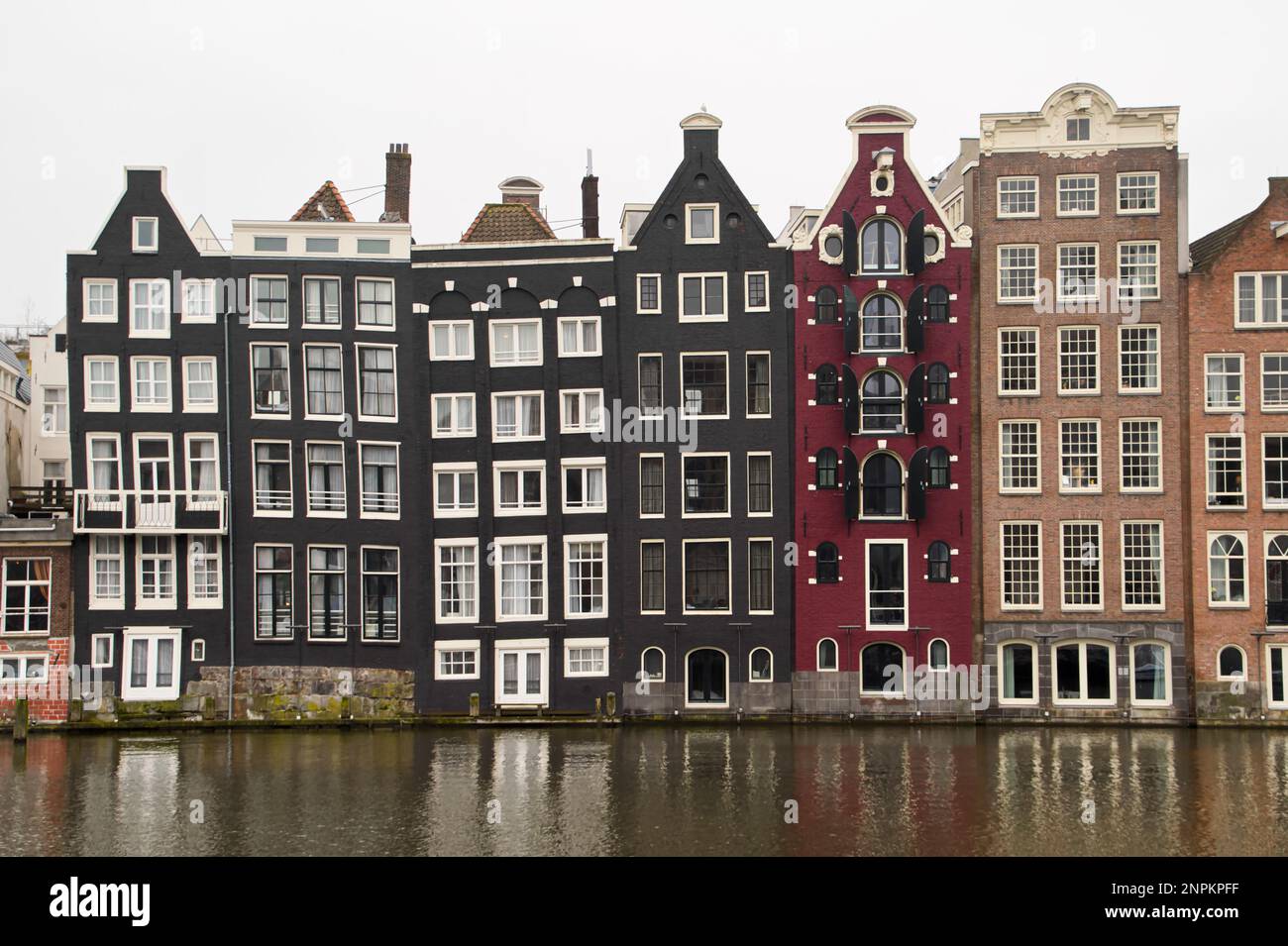 Die engen Grachtenhäuser in Amsterdam, die Tanzhäuser, die im Winter über Damrak in den Niederlanden geführt wurden Stockfoto
