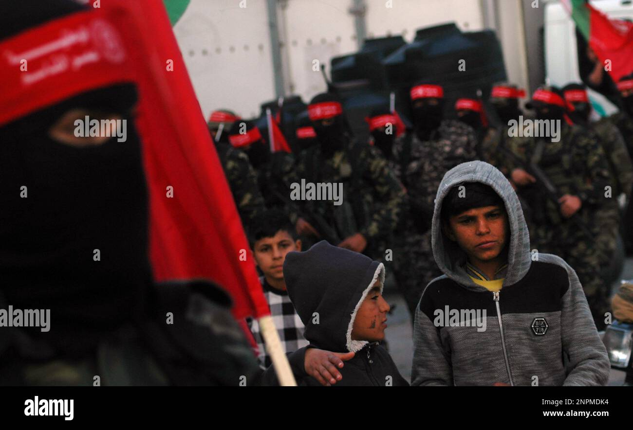 Rafah, Gaza. 26. Februar 2023. Palästinensische Jungen betrachten maskierte Kämpfer der Demokratischen Front für die Befreiung Palästinas (DFLP) bei einer Parade in Rafah-Stadt im südlichen Gazastreifen am Sonntag, den 26. Februar 2023, zur Unterstützung des Westjordanlands und der Palästinenser in israelischen Gefängnissen und gegen den palästinensisch-israelischen Gipfel in Akaba. Foto: Ismael Mohamad/UPI Credit: UPI/Alamy Live News Stockfoto