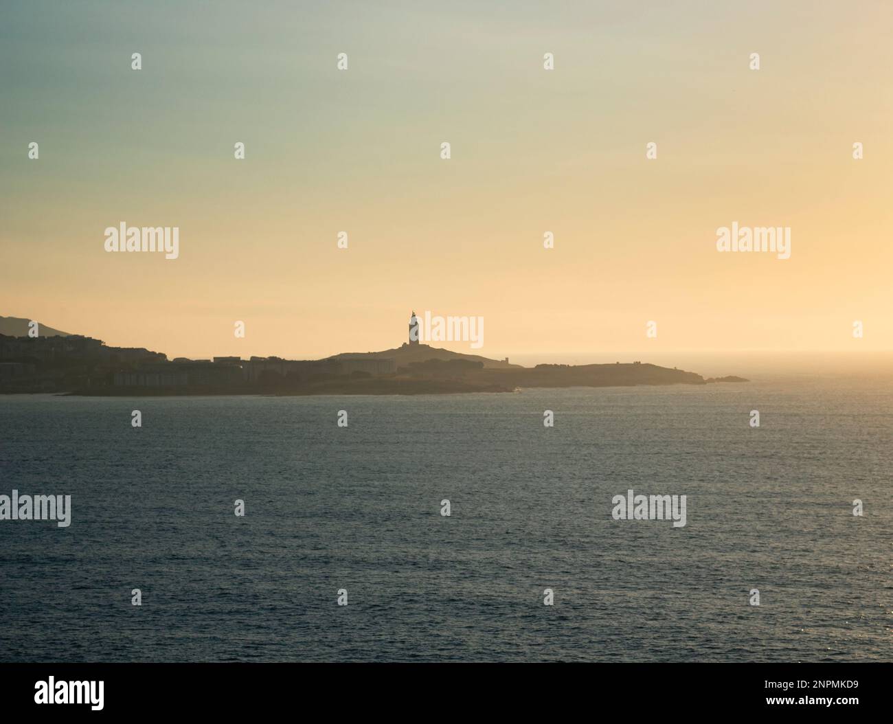 Turm des Herkules am Horizont, beleuchtet von den letzten Sonnenstrahlen bei Sonnenuntergang. Gelegen in Einem Coruña, Galicien, und von historischem Interesse, Kopie s Stockfoto
