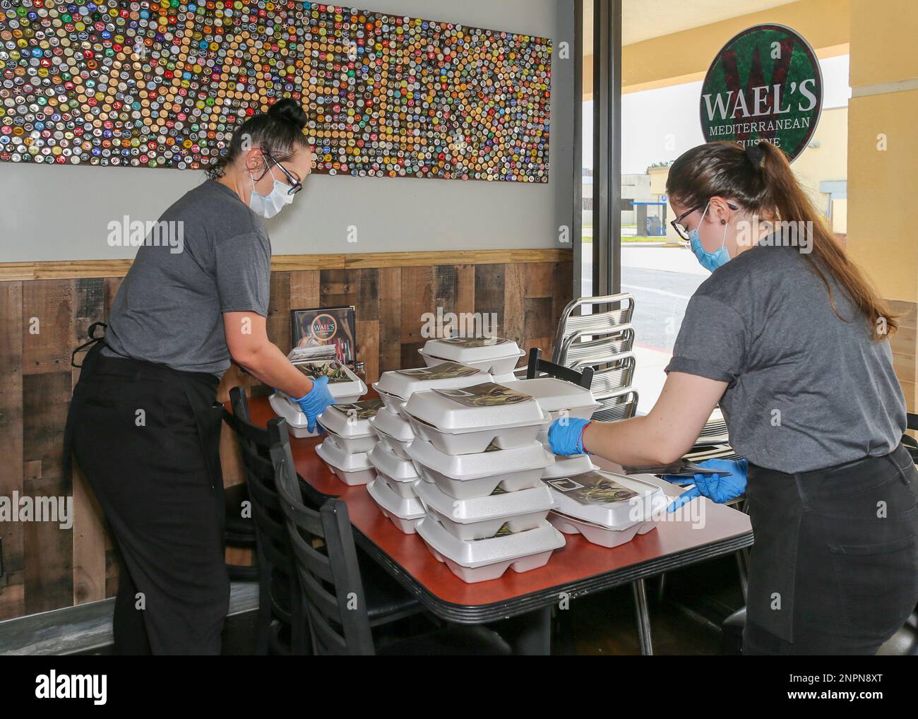 HOUSTON, TX - AUGUST 09: Wael's Mediterranean Cuisine servers tape menus to carryout boxes on August 09, 2020, in Houston, TX. The restaurant is donating hundreds of free meals to first responders and the unemployed affected by the coronavirus (COVID-19) pandemic. (Photo by Leslie Plaza Johnson/Icon Sportswire) (Icon Sportswire via AP Images) Stockfoto