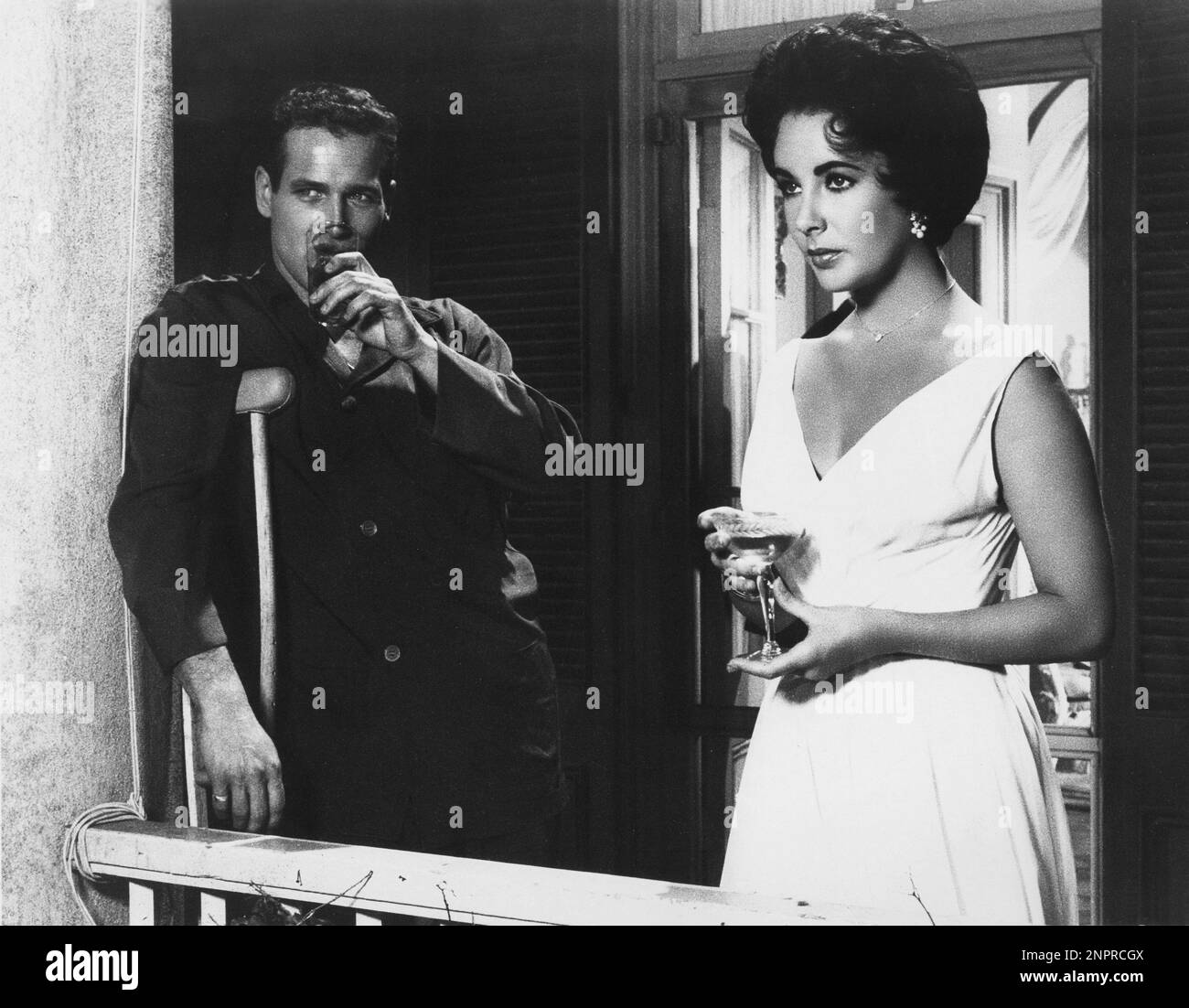 1958 : die Filmschauspielerin ELIZABETH TAYLOR ( London , England 1932 ) und PAUL NEWMAN in DER Show CAT ON A HOT TIN ROOF ( La gatta sul tetto che scotta ) von Richard Brooks , Aus einem Stück von Tennessee Williams - KINO - Portrait - Rituto - Innamorati - Aanti - Liebhaber - Marihuana e Moglie - Ehemann und Frau - Pigiama - Pyjama - Drink - Liz - collana - Halskette - Orekchino - Orekchini - Ohrentropfen - Juwelen - gioiello - gioielli - Abito vestito bianco - weißes Kleid - SCHWUL - Homosexualität - omosessualità - Omossuale - homosexuell - Gruccia - Stampella - Cocktail --- Archivio GBB Stockfoto