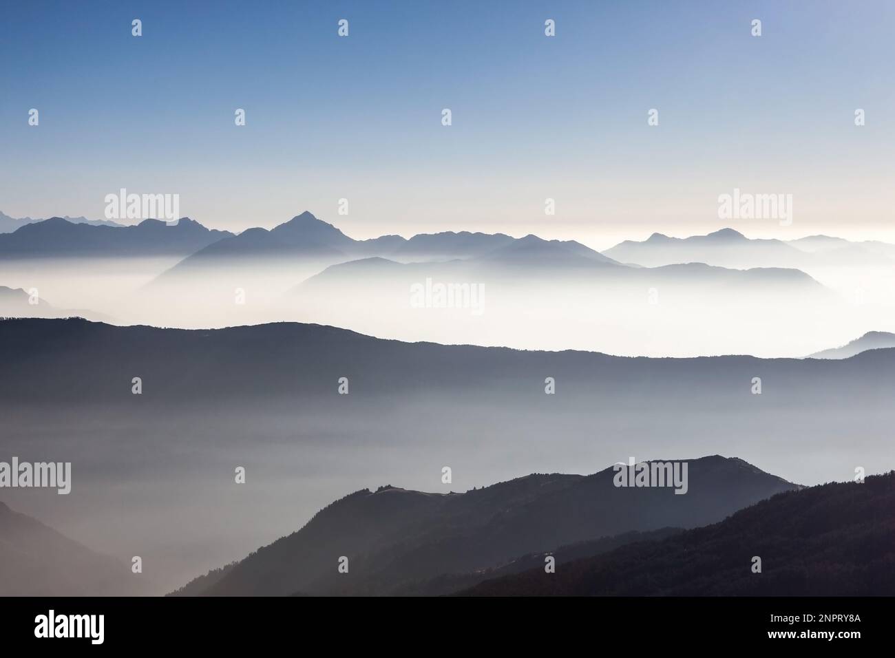 Neblige Berglandschaft im Himalaya, Nepal. Wunderschönes Bergtal mit frühmorgendlichem Nebel. Dramatisch neblige Bergkette erhebt sich über Weiß Stockfoto