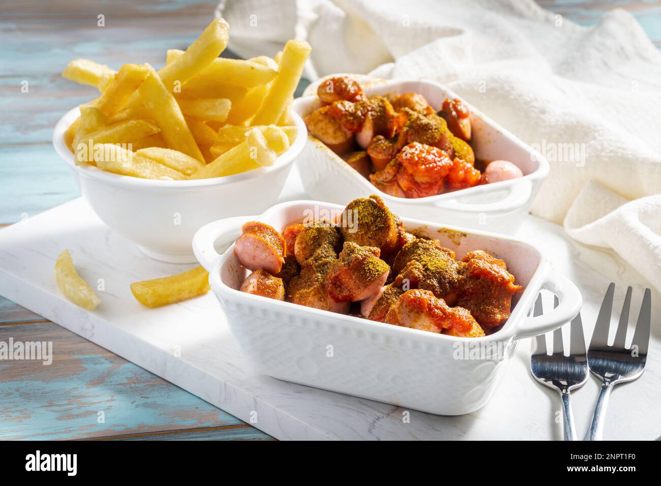 Hausgemachte Currywurst. Deutsches Fast-Food-Gericht mit gebratener Schweinewurst, Curryketchup und Currypulver Stockfoto