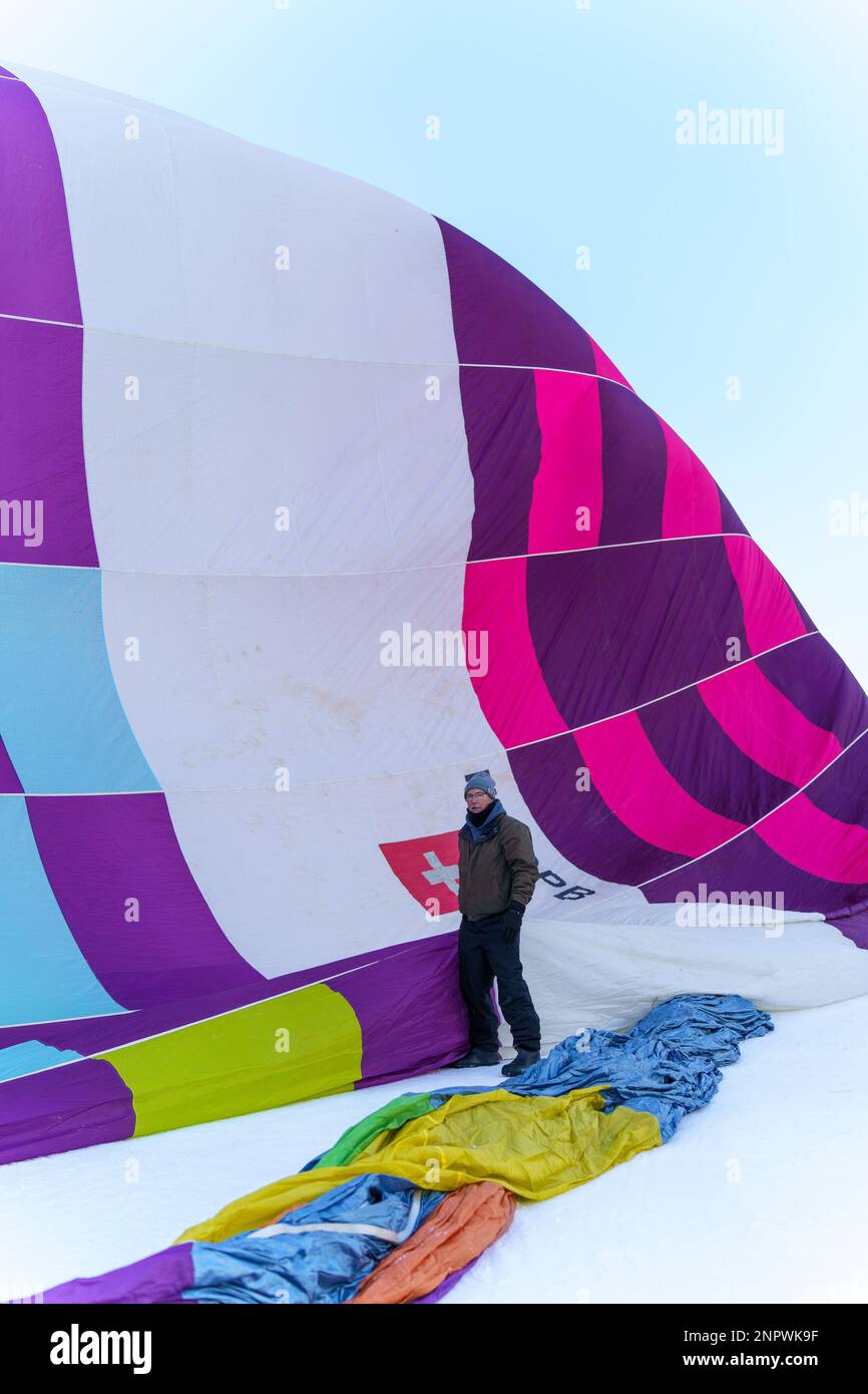Ein Mann, der vor einem Ballon steht. Aufgenommen beim 42. Internationalen Ballonfestival in Chateau D'Oex im Januar 2023. Stockfoto