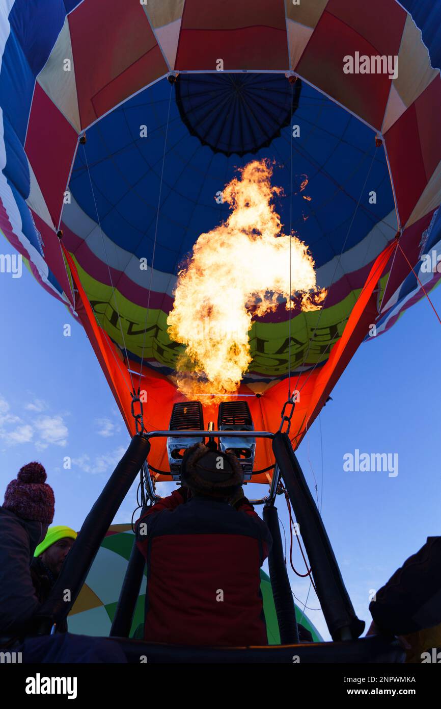 Ich zünde den Brenner eines Heißluftballons an. Aufgenommen beim 42. Internationalen Ballonfestival in Chateau D'Oex im Januar 2023. Stockfoto