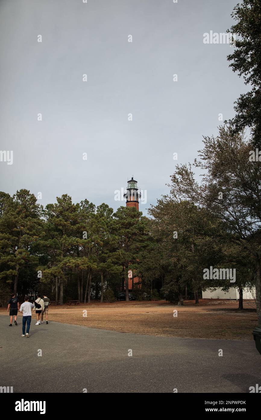 Old Brick Lighthouse mit Blick auf Wald und Dock mit Strand Stockfoto