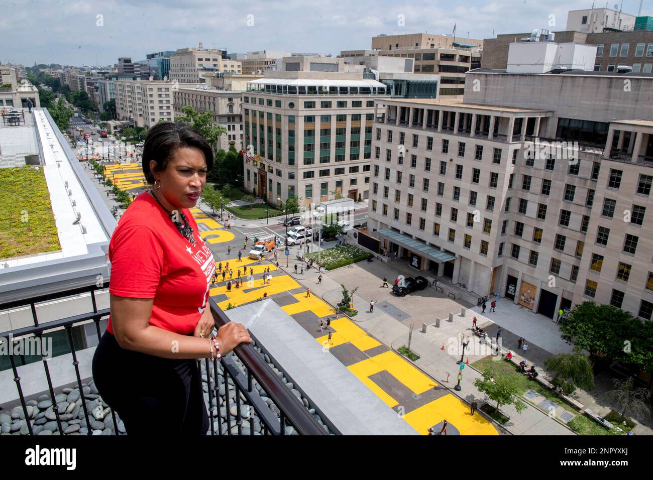 In this image provided by the Executive Office of the Mayor, District of Columbia Mayor Muriel Bowser stands on the rooftop of the Hay Adams Hotel near the White House and looks out at the words 'Black Lives Matter' that have been painted in bright yellow letters on the street by city workers and activists, Friday, June 5, 2020, in Washington. (Executive Office of the Mayor/Khalid Naji-Allah via AP) Stockfoto