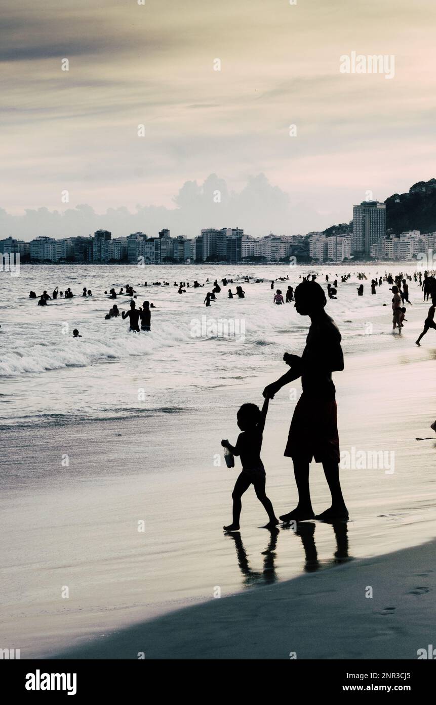 Silhouette von Frau und Kind am Strand der Copacabana in Rio de Janeiro, Brasilien Stockfoto