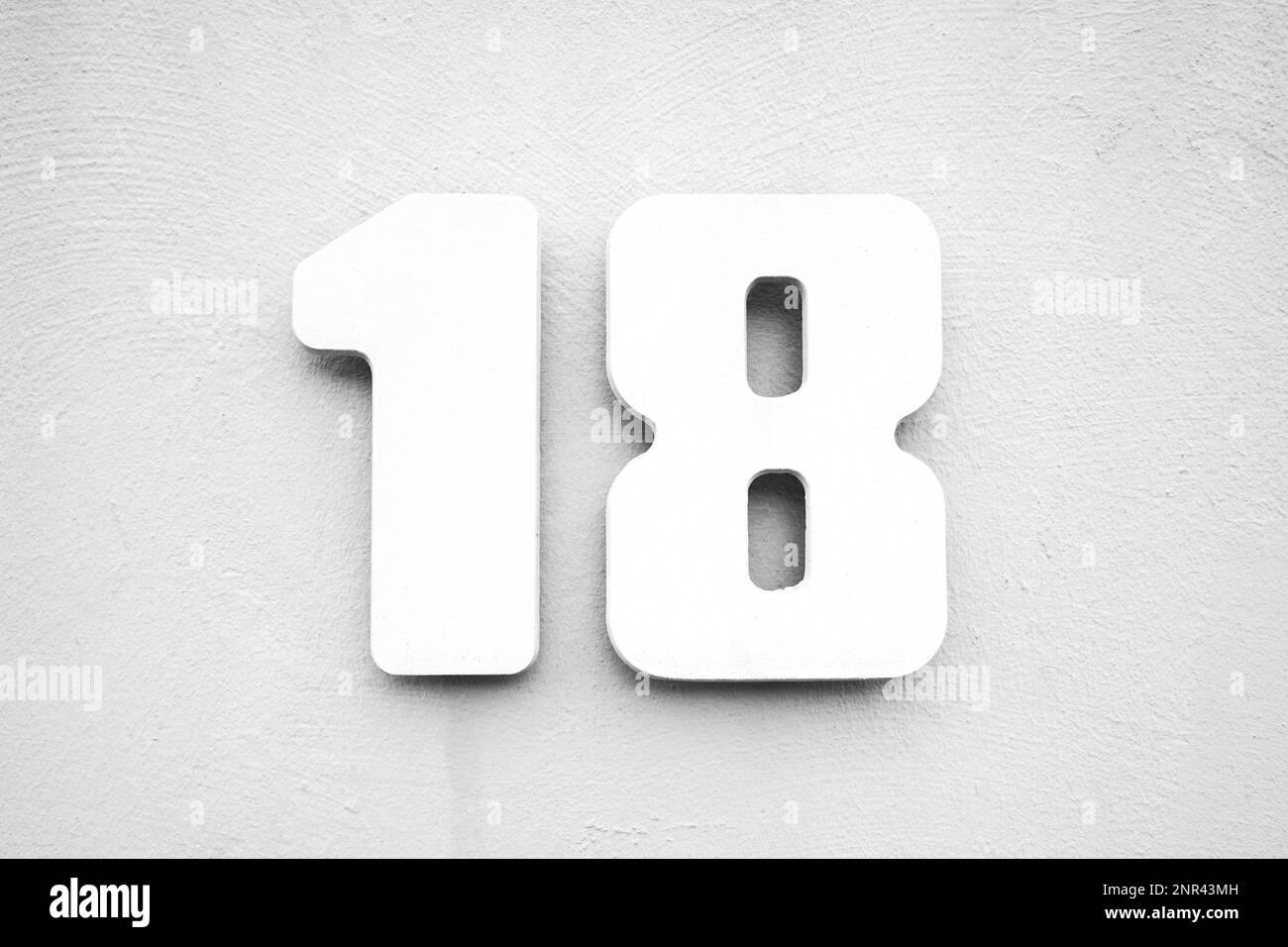 Haus Nummer 18 auf texturierte Wand, weiß auf grau Stockfoto