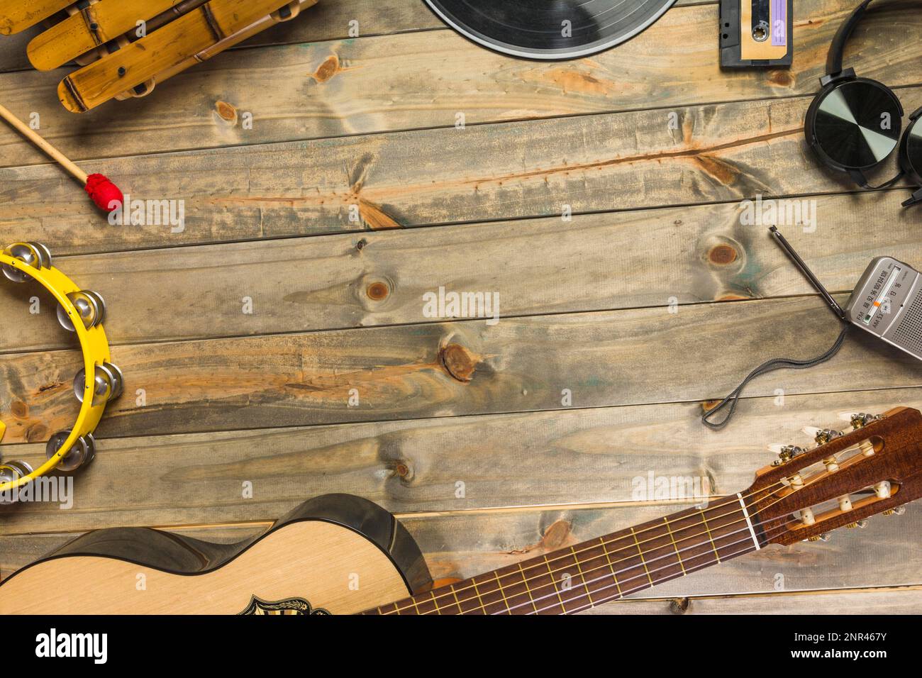 Nahaufnahme Gitarrenkopfhörer Tamburin Xylophon Kopfhörerradio Holztisch mit Weltraumtext. Schönes Foto Stockfoto