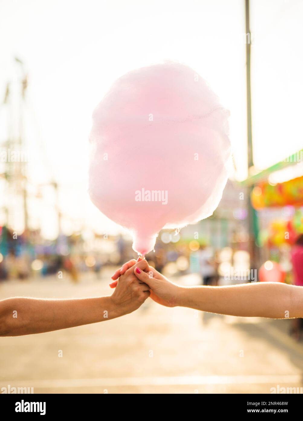 Nahaufnahme der Hand von zwei Frauen mit rosa Süßigkeiten-Zahnseide. Schönes Foto Stockfoto