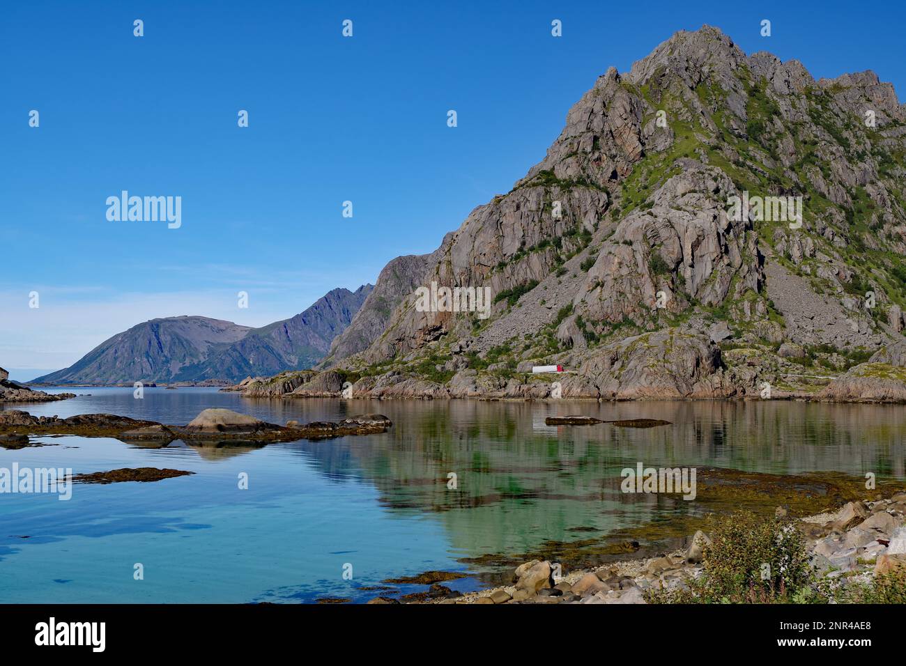 Flache Bucht mit kristallklarem Wasser vor dem Hochgebirge, Henningsvaer, Festvagtind, Gemeinde Vagan, Provinz Nordland, Norwegen Stockfoto