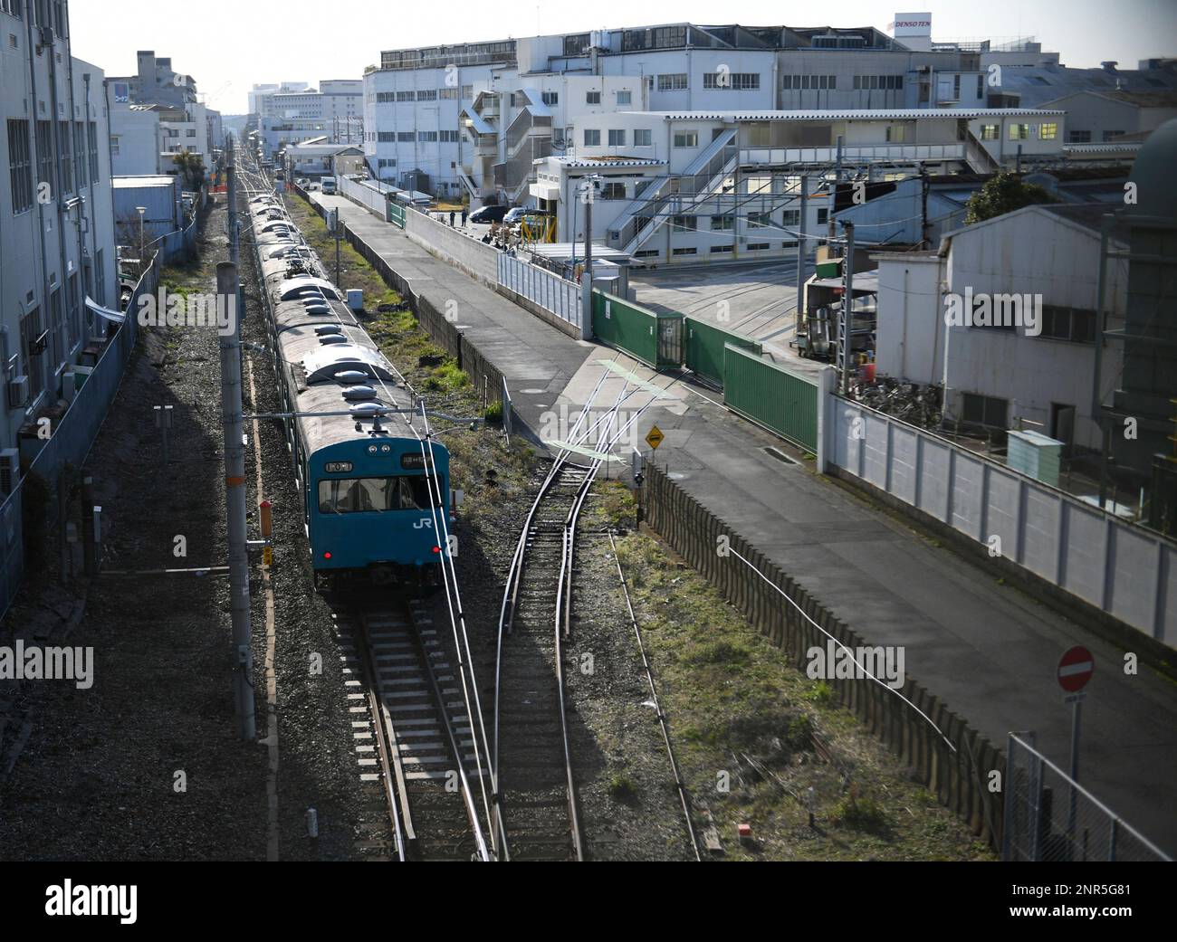 A picture shows a train of Wadamisaki Line, operated by West Japan Railway Company running by a factory of Kawasaki Heavy Industries in Kobe, Hyogo Prefecture on March 17, 2020. Wadamisaki Line, a spur line of the Sanyo Main Line coneectiong Hyogoname for Hyogo and Wadamisaki Station, started in 1890.( The Yomiuri Shimbun via AP Images ) Stockfoto