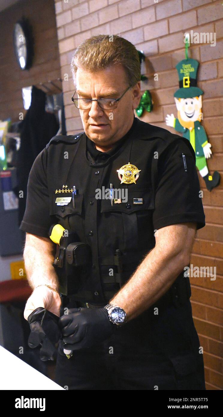Ashtabula County Common Pleas Court bailiff Steve Gerics puts on gloves before greeting visitors to the Ashtabula County Courthouse in Jefferson, Ohio, on Thursday March 12, 2020. Visitation at the county jail has been temporarily suspended due to the coronavirus. (Warren Dillaway/The Star-Beacon) Stockfoto