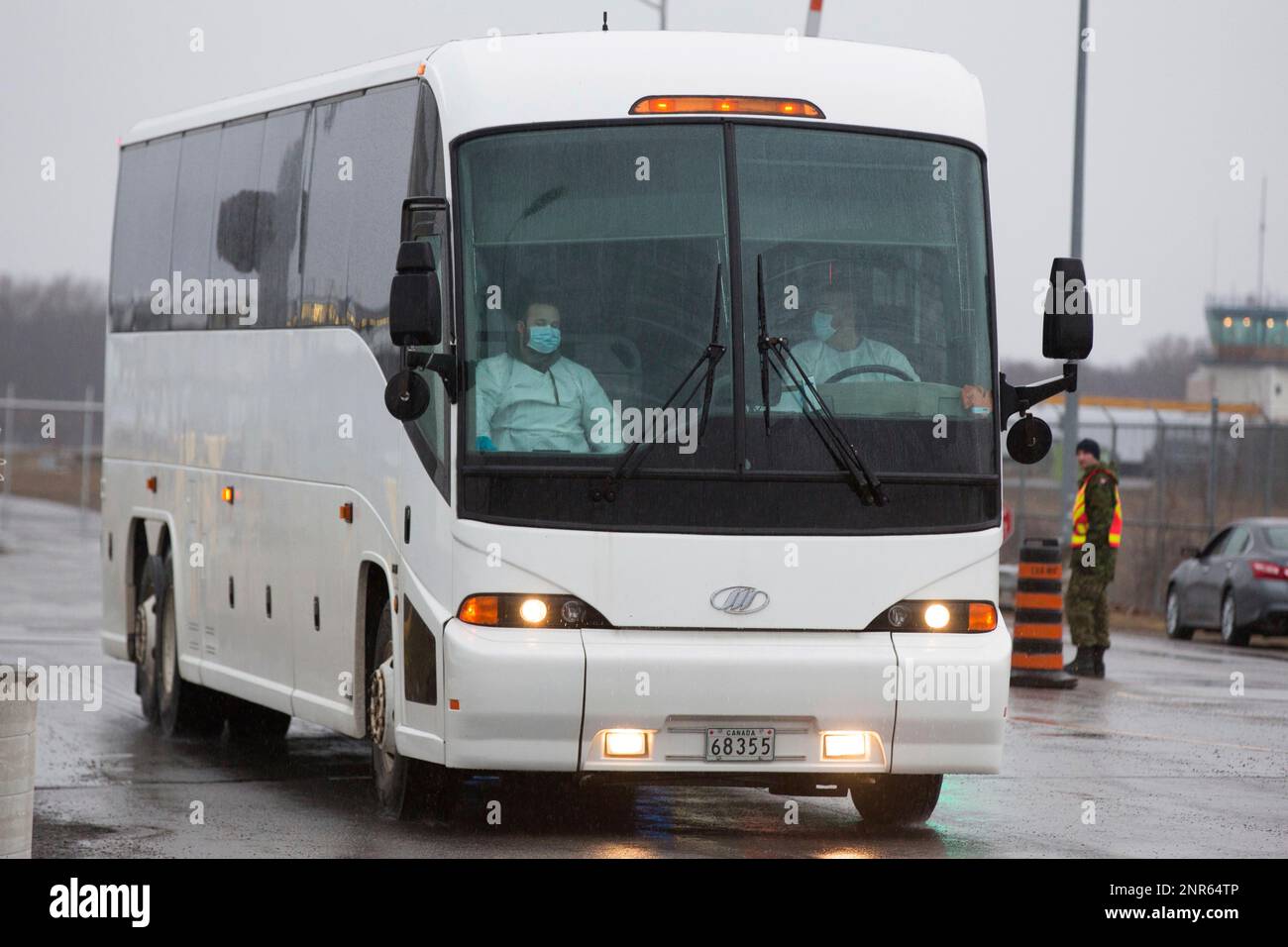 A bus carrying Canadian passengers from the Grand Princess cruise ship drives away after arriving on a government plane from Oakland, Calif. to Canadian Forces Base Trenton in Trenton, Ont., on Tuesday, March 10, 2020. After days of being forced to idle off the Northern California coast, the Grand Princess docked Monday in Oakland with some 3,500 passengers and crew aboard. (Lars Hagberg /The Canadian Press via AP) Stockfoto