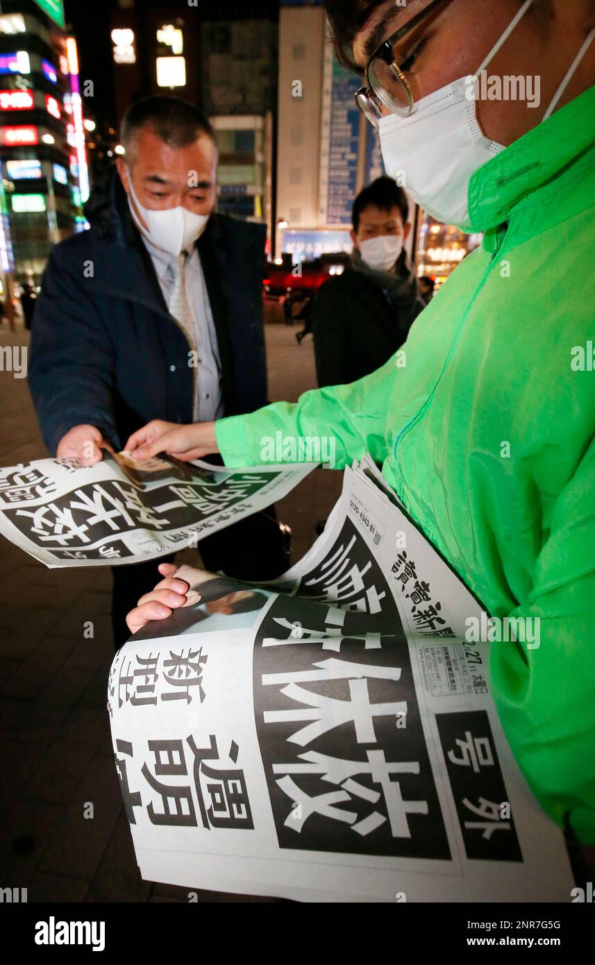 The extra edition of newspaper is distributed in Tokyo on Feb. 27, 2020. On the same day, Japan's Prime Minister Shinzo Abe, at the meeting for the Countermeasures against the New Coronavirus, has requested all elementary schools, junior high schools, high schools and Schools for Special Needs Education to temporarily close from March 2nd. ( The Yomiuri Shimbun via AP Images ) Stockfoto