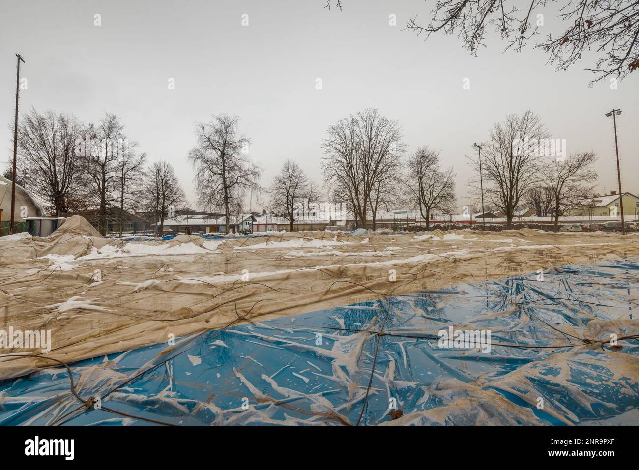 Entlüftete Kuppel für Sporthalle auf dem Boden aufgrund von starkem Schnee oder Durchstich. Sporthalle aus einer Kuppel, aber jetzt leer. Stockfoto